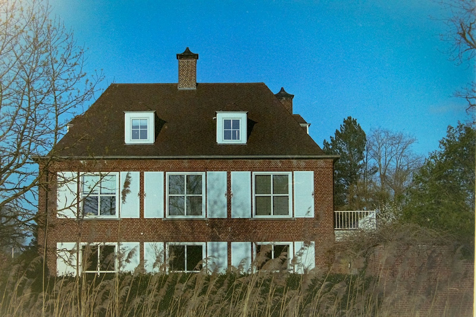 a large brick house sitting in the middle of a field